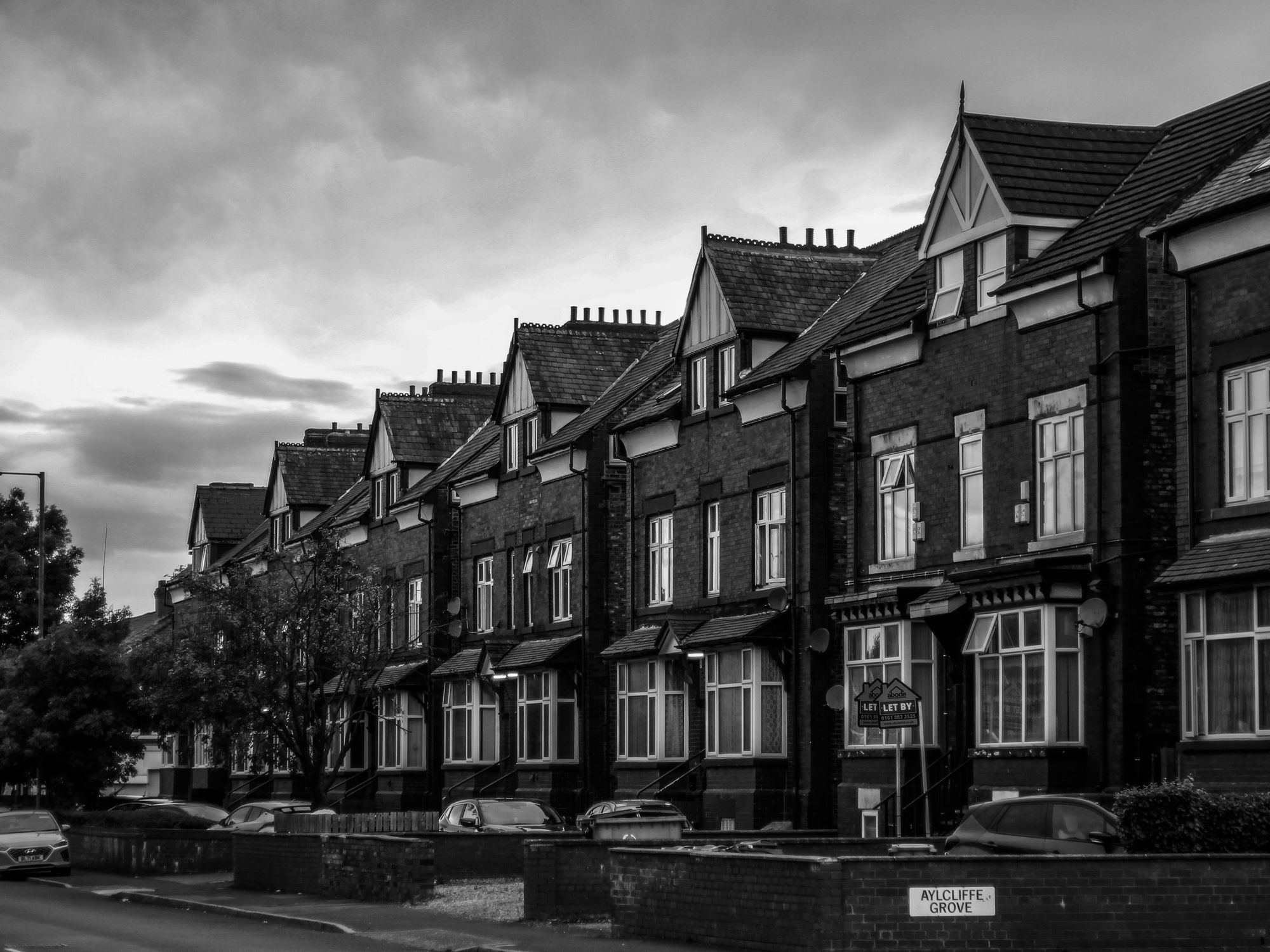 Elegant black and white photo of Victorian terraced houses in Manchester, England.