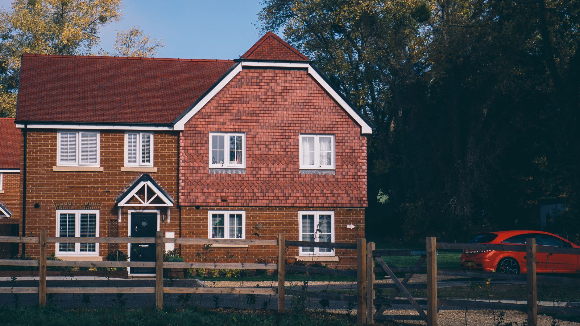 Quaint English family home with red brick and car in Farnham.